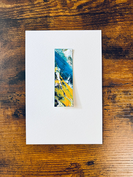 Original miniature abstract painting featuring teal blue, yellow ochre, yellow, mint green and white colors. Acrylic paint and tar gel medium textured cold press watercolor paper, mounted on 4x6-inch watercolor paper in portrait orientation and photographed on a wooden table.